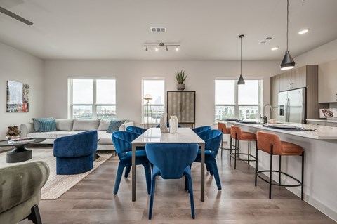 an open concept living room and kitchen area with a dining table and chairs and a kitchen island