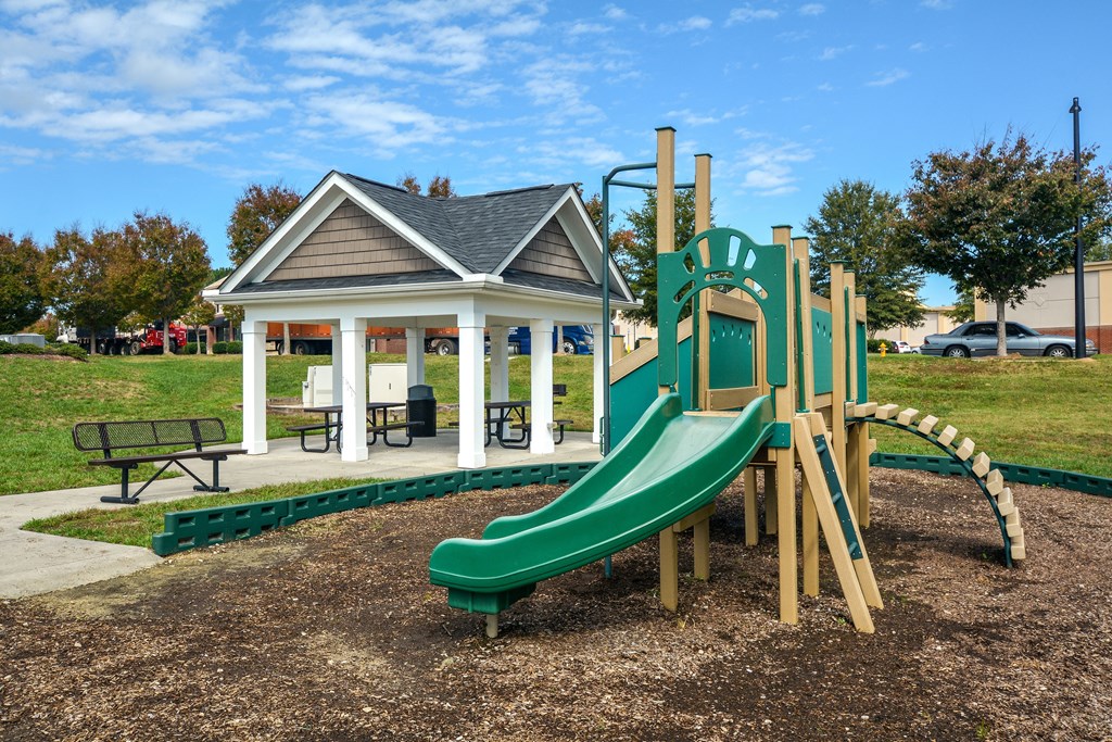 a playground with a slide and a gazebo in a park