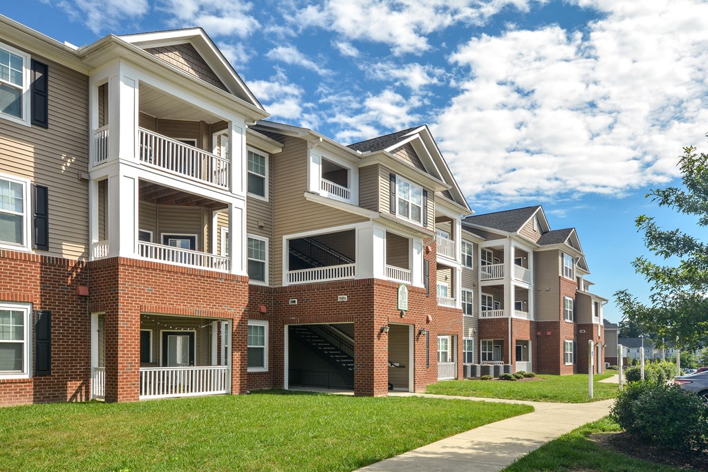 an apartment building with a sidewalk in front of it