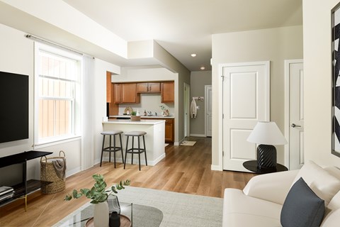 A living room with a white couch and a glass coffee table.