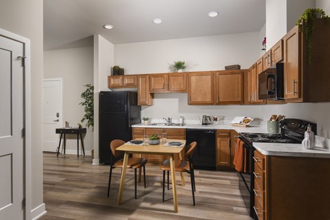 A kitchen with black appliances and wooden cabinets.
