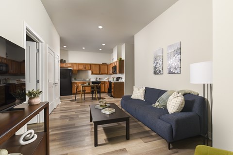 A living room with a blue couch and a wooden coffee table.