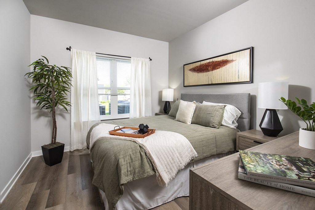 a bedroom with a large bed and a potted plant