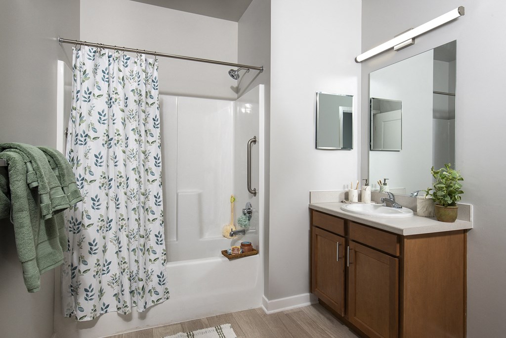 a bathroom with a shower and a sink and a mirror