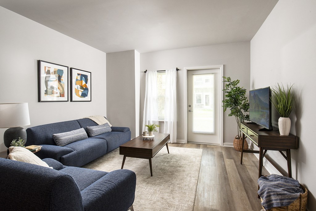 a living room with a blue couch and a tv