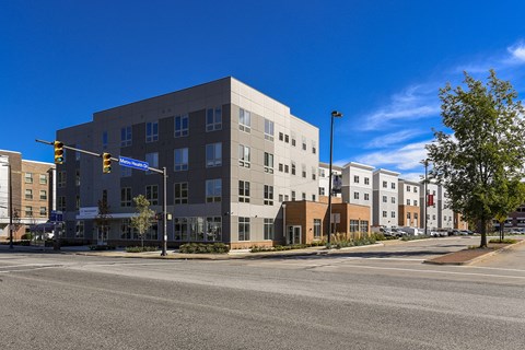 Modern apartment community featuring contemporary architecture, landscaped streetscapes, and a prominent corner location near neighborhood amenities.