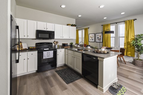 A modern kitchen with white cabinets and a black stove top oven.
