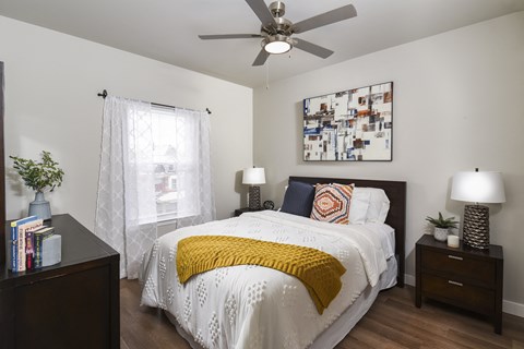 Inviting bedroom with contemporary décor, warm wood-style flooring, and abundant natural light