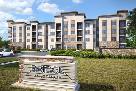 an apartment building with a sign in front of it