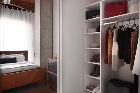 A bedroom with a bed, a wardrobe and a window.
