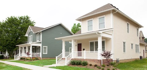 A house with a green and beige exterior.