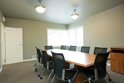 A conference room with a long table and chairs.