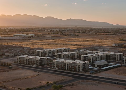 A housing development in a desert with mountains in the background.