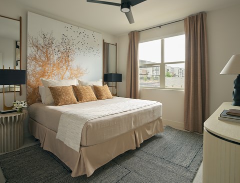 A bedroom with a large bed and a ceiling fan.