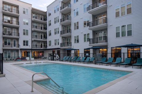 A swimming pool in front of apartment buildings.