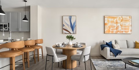 A modern dining room with a wooden table and chairs.