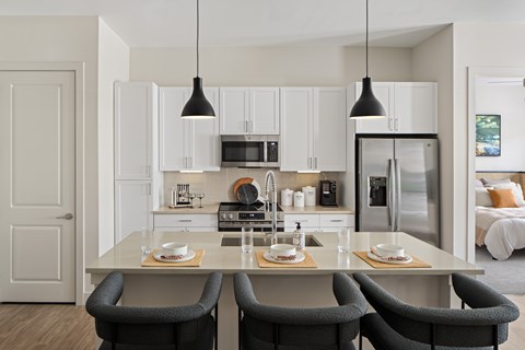 A modern kitchen with a dining table set for two.