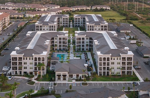 A large, multi-story residential complex with a central pool.
