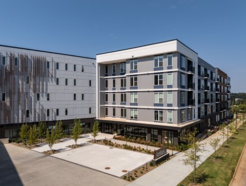 A modern building with a parking lot in front.