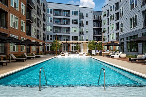 A large swimming pool in front of apartment buildings.