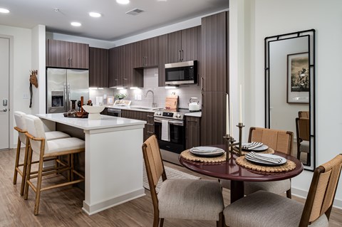 A modern kitchen with a dining table set for four.