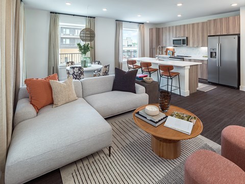 A modern living room with a grey sofa and a wooden coffee table.