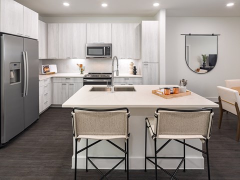 A modern kitchen with white cabinets and a large island.
