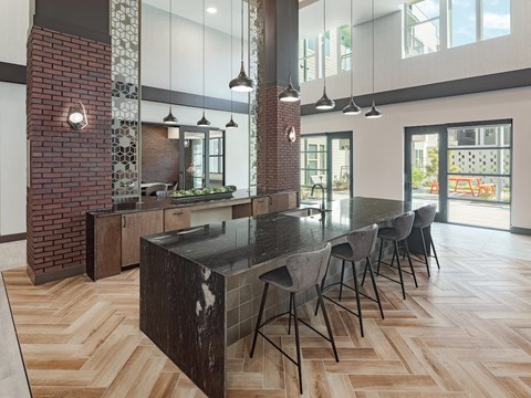 A modern kitchen with a long black table and chairs.