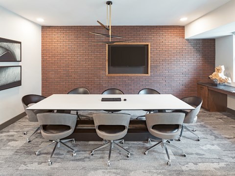 A conference room with a white table and chairs.