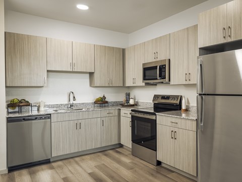 A modern kitchen with wooden cabinets and stainless steel appliances.