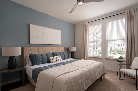 A bedroom with a large bed and a ceiling fan.