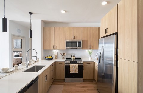 A modern kitchen with wooden cabinets and stainless steel appliances.