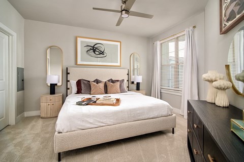 A bedroom with a large bed and a ceiling fan.