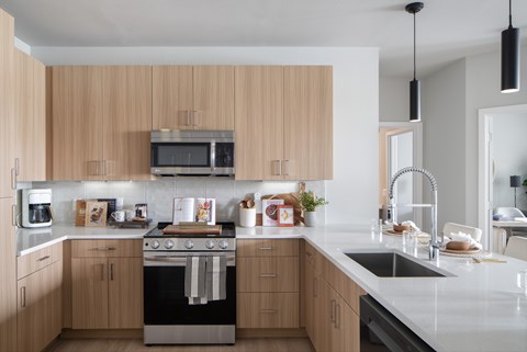 A modern kitchen with wooden cabinets and stainless steel appliances.