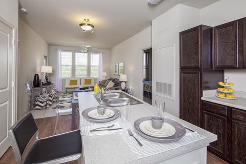 A modern kitchen with a dining table set for two.