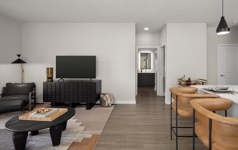 A modern living room with a black sofa and a wooden coffee table.