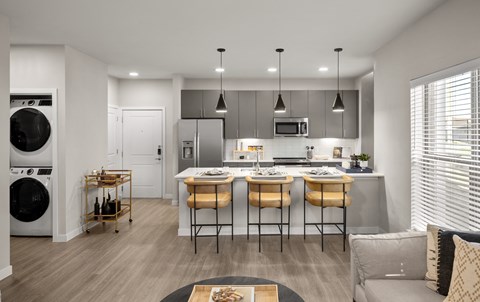 A modern kitchen with a dining table set for two.
