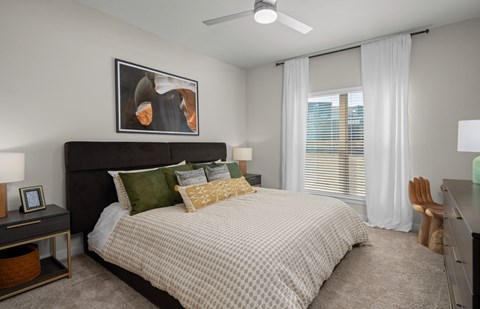 a bedroom with a large bed and a ceiling fan
