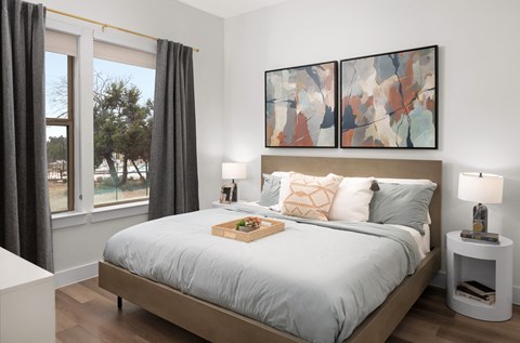 Spacious primary bedroom featuring comfortable furnishings, abundant natural light, and a relaxing atmosphere designed for everyday comfort.