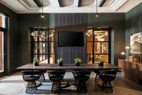 A modern dining room with a long table and chairs.
