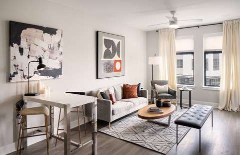 A modern living room with a white dining table and a grey sofa.
