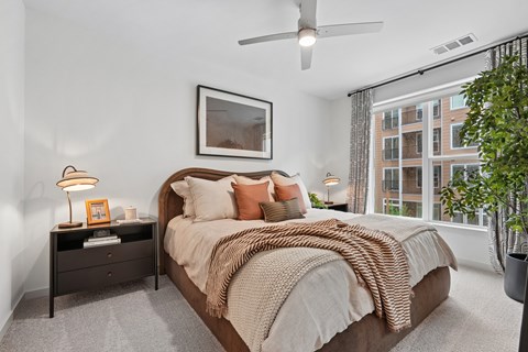 A bedroom with a large bed and a ceiling fan.