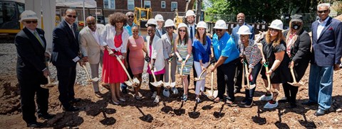 a group of people with shovels standing in front of a construction site