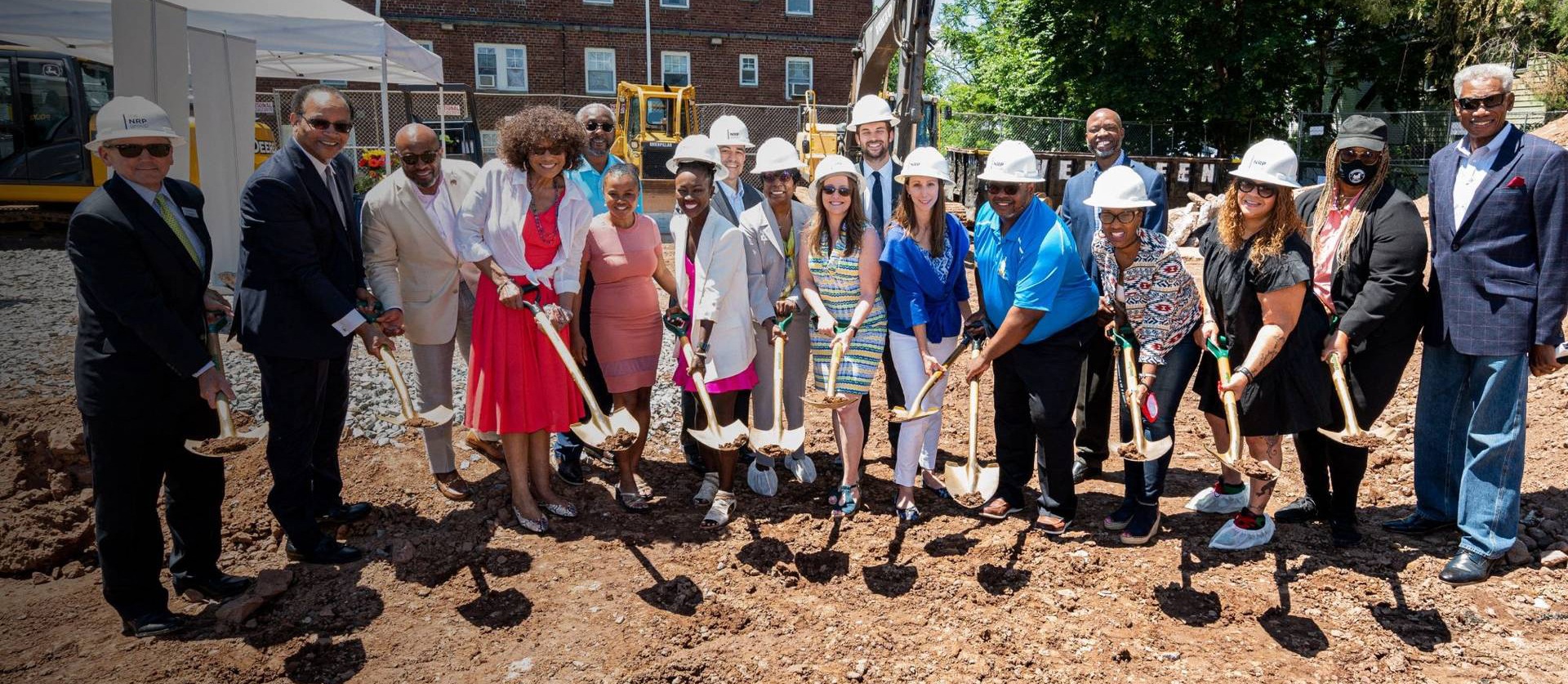 a group of people holding shovels in a dirt field