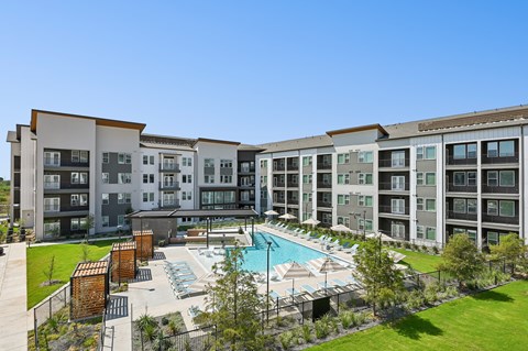 A large apartment complex with a pool in the middle.
