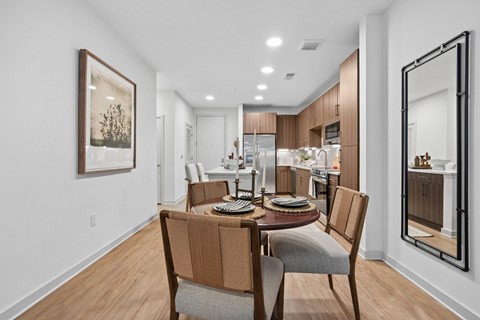 A modern dining room with a wooden table and chairs.