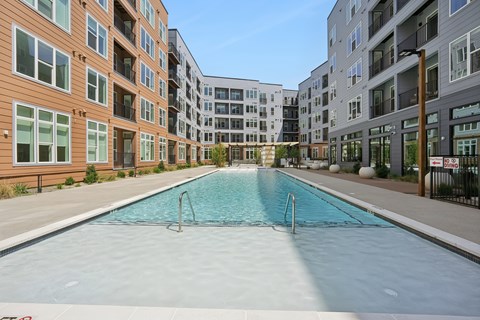 A swimming pool in front of apartment buildings.