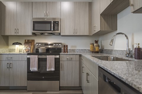 A modern kitchen with a stove top oven and microwave above it.