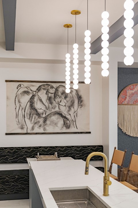 A kitchen with a sink and a painting on the wall.