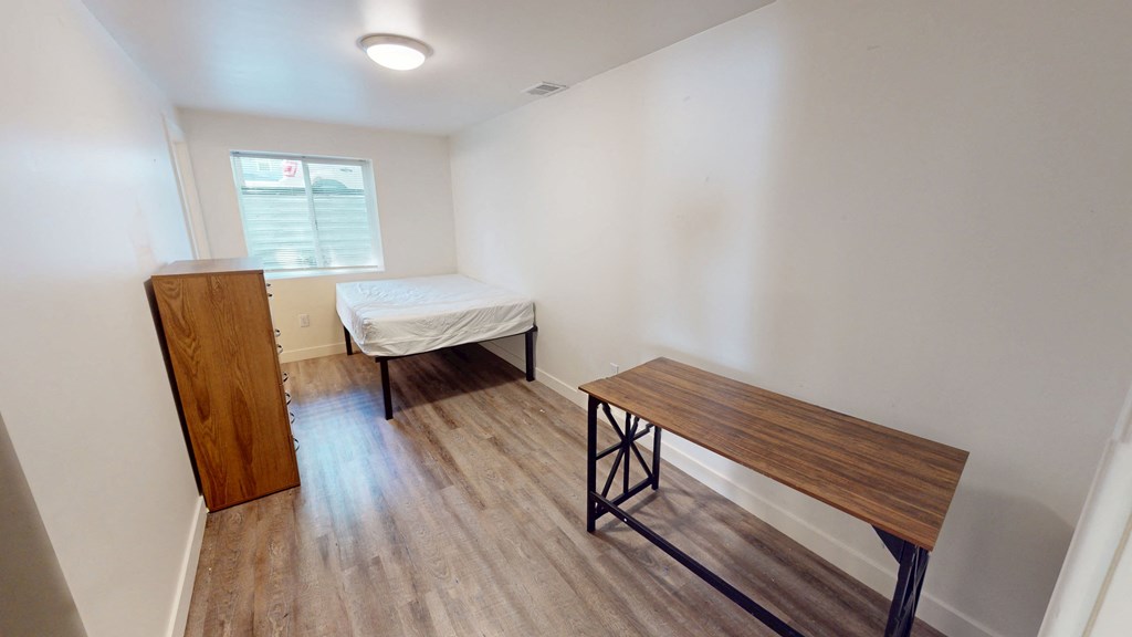 A room with a bed and a bench.